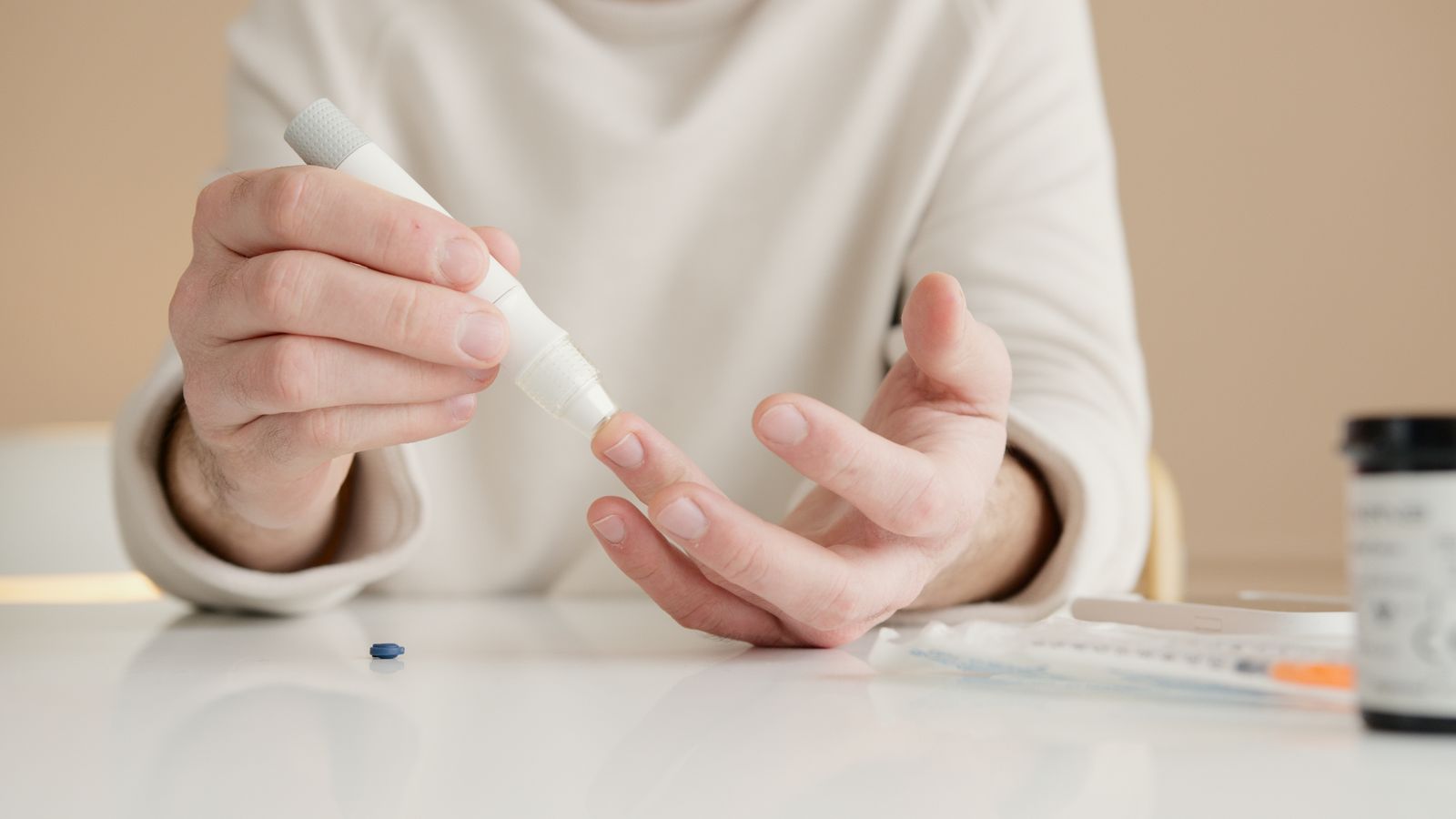 Una persona misura la glicemia pungendo il polpastrello con il pungidito