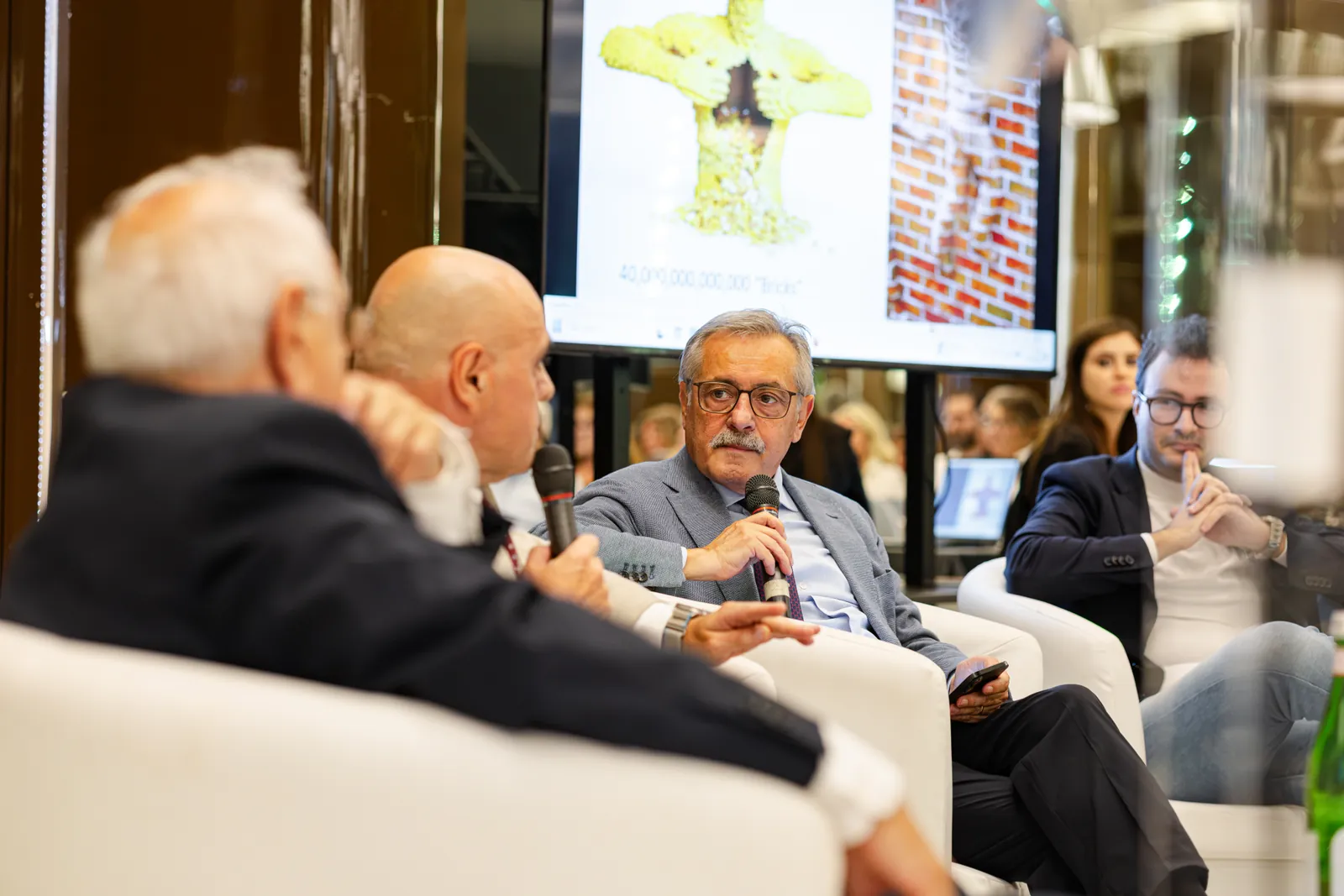 Il confronto sul palco, con le slide proiettate alle spalle