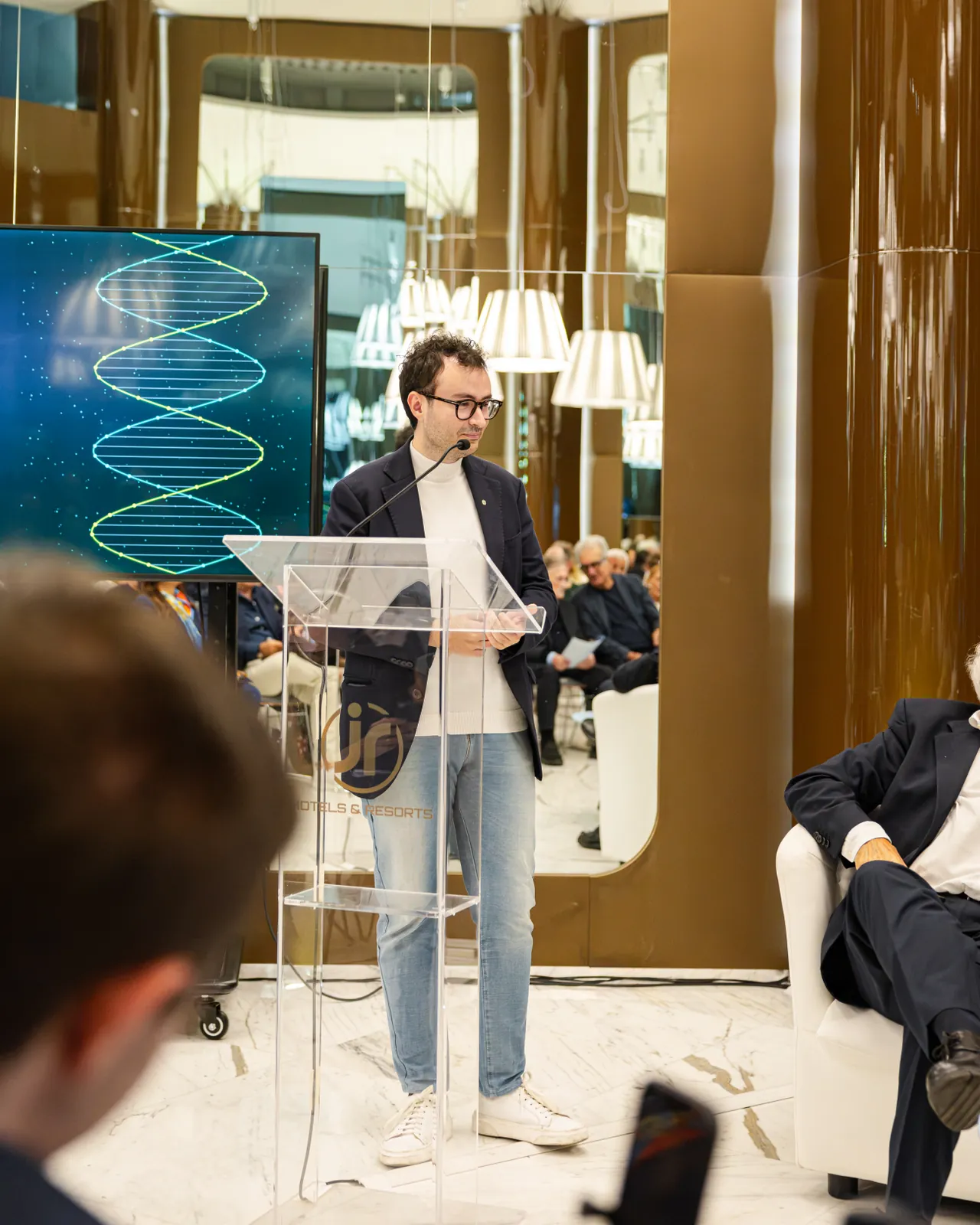 Al leggio, sotto lo schermo con la doppia elica del DNA
