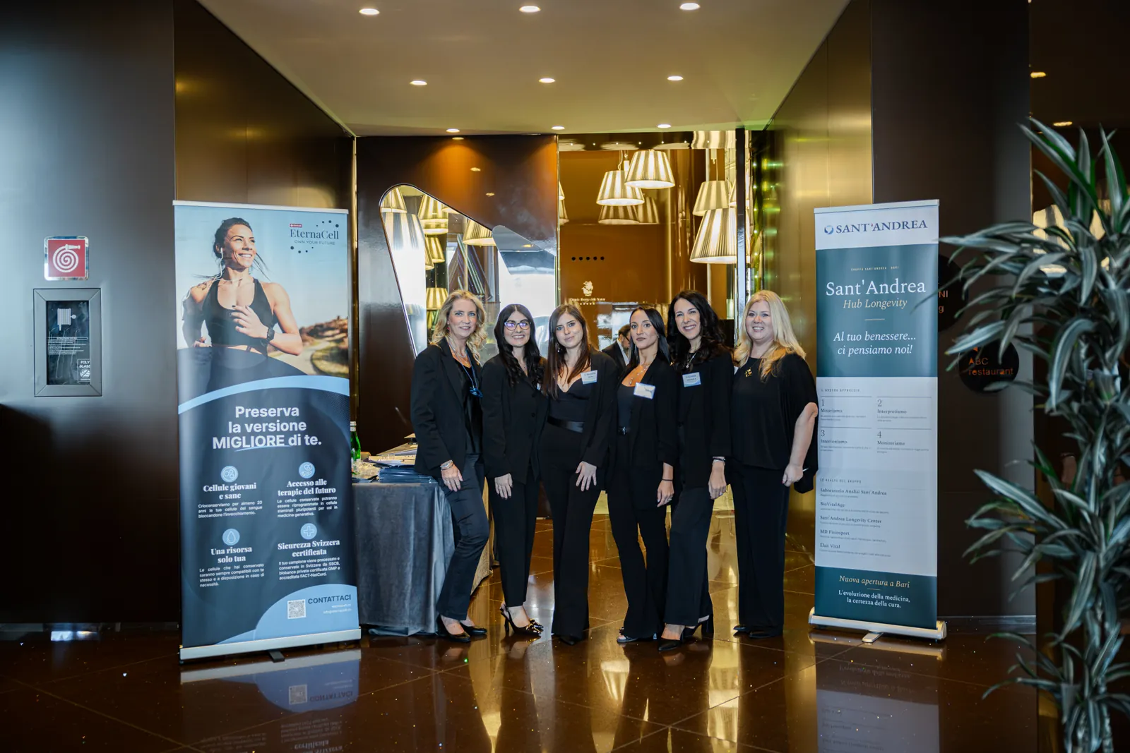 Foto di gruppo all'ingresso, accanto ai roll-up di Sant'Andrea – Hub Longevity